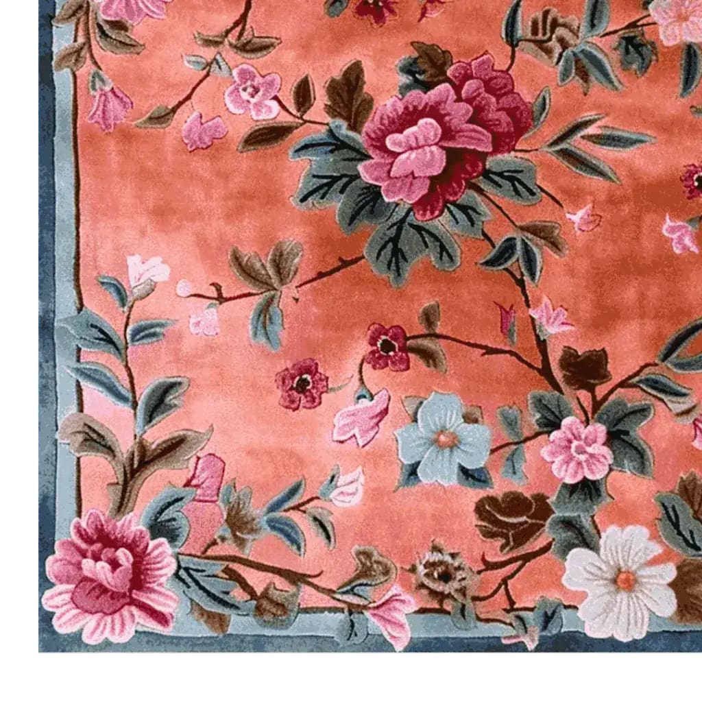 A close-up of 'The Secret Garden Hand Knotted Rug' showcasing intricate floral patterns in vibrant pink and green hues. This wool area rug is perfect for enhancing the elegance of living room and dining room spaces, making it an ideal choice for both casual and formal dining room settings.