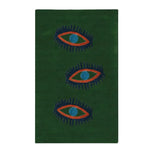 A top view of the Three Evil Eyes Green Hand Tufted Wool Rug, featuring a striking design of three abstract eyes in bold colors on a rich green background. This area rug is perfect as a dining table rug, adding a vintage touch to your dining room or bedroom decor. It also serves as an elegant kitchen rug or hallway runner rug.