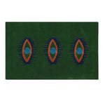 Green hand-tufted wool rug featuring a unique design with three abstract eye patterns in blue and orange. Ideal as an area rug, this versatile piece can enhance spaces like kitchens, bedrooms, or hallways, adding a vintage touch to your home decor.
