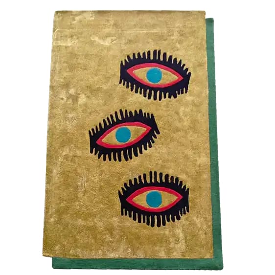 Top view of the Three Evil Eyes Viscose Hand Tufted Wool Rug, featuring a bold and artistic design with three stylized eyes on a beige background, bordered by a green edge. Perfect for adding a unique touch to living room and dining room spaces. This vintage-inspired wool rug is an ideal choice for formal dining room settings.