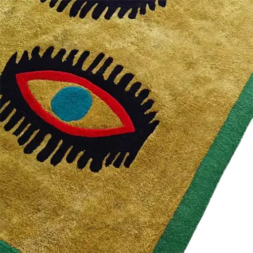 Close-up view of the Three Evil Eyes Viscose Hand Tufted Wool Rug, featuring an abstract eye design with bold colors. Perfect for adding a touch of vintage style to living rooms and dining rooms, this area rug serves as a striking centerpiece for formal dining room settings.