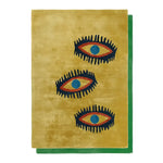 A stylish area rug featuring an abstract design of three eye symbols on a warm yellow background. This wool rug is perfect for adding a vintage touch to living rooms and dining rooms. The bold design makes it an ideal choice for both living room and formal dining room settings.