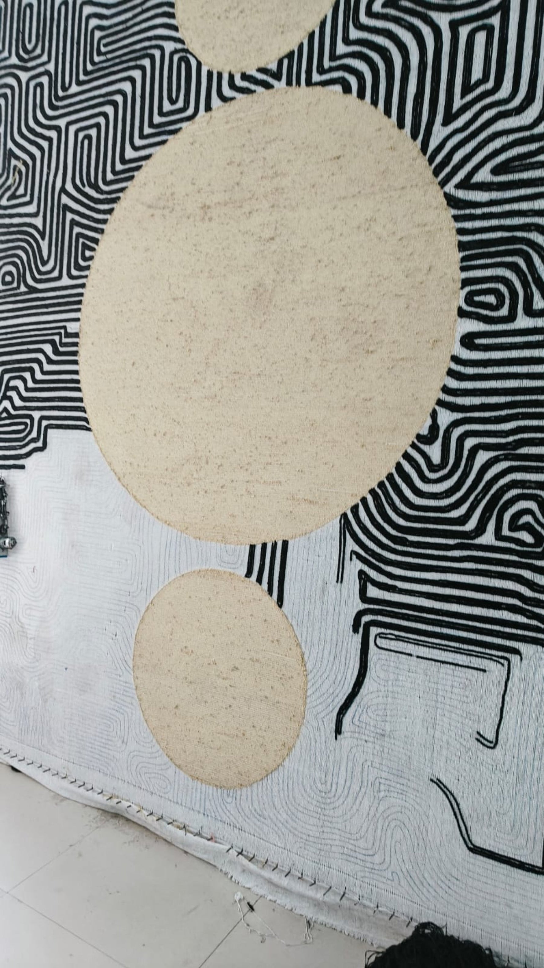 Round beige coasters on a black and white patterned surface