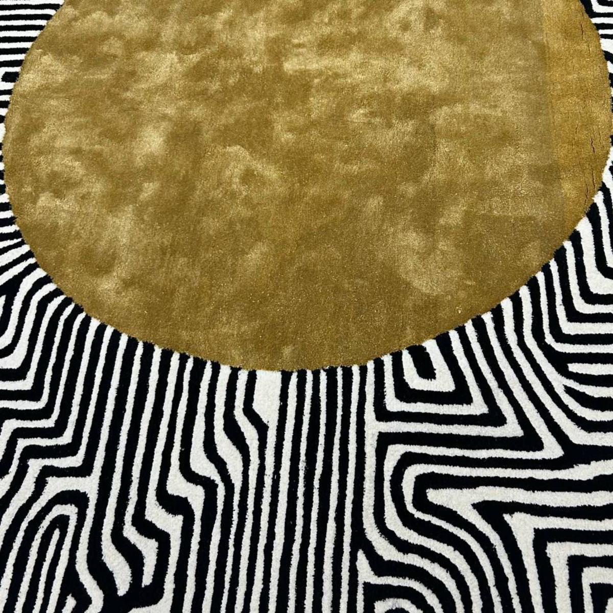 Round gold rug on a black and white patterned floor