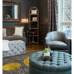 A stylish living room featuring a Three Golden Suns Maze Hand Tufted Wool Area Rug. The large area rug, perfect for living rooms 8x10, showcases a striking geometric design with golden sun patterns. It complements the elegant tufted furniture and sophisticated decor, adding warmth and style to the space.