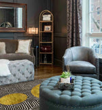 A stylish living room featuring a Three Golden Suns Maze Hand Tufted Wool Area Rug. The large area rug, perfect for living rooms 8x10, showcases a striking geometric design with golden sun patterns. It complements the elegant tufted furniture and sophisticated decor, adding warmth and style to the space.