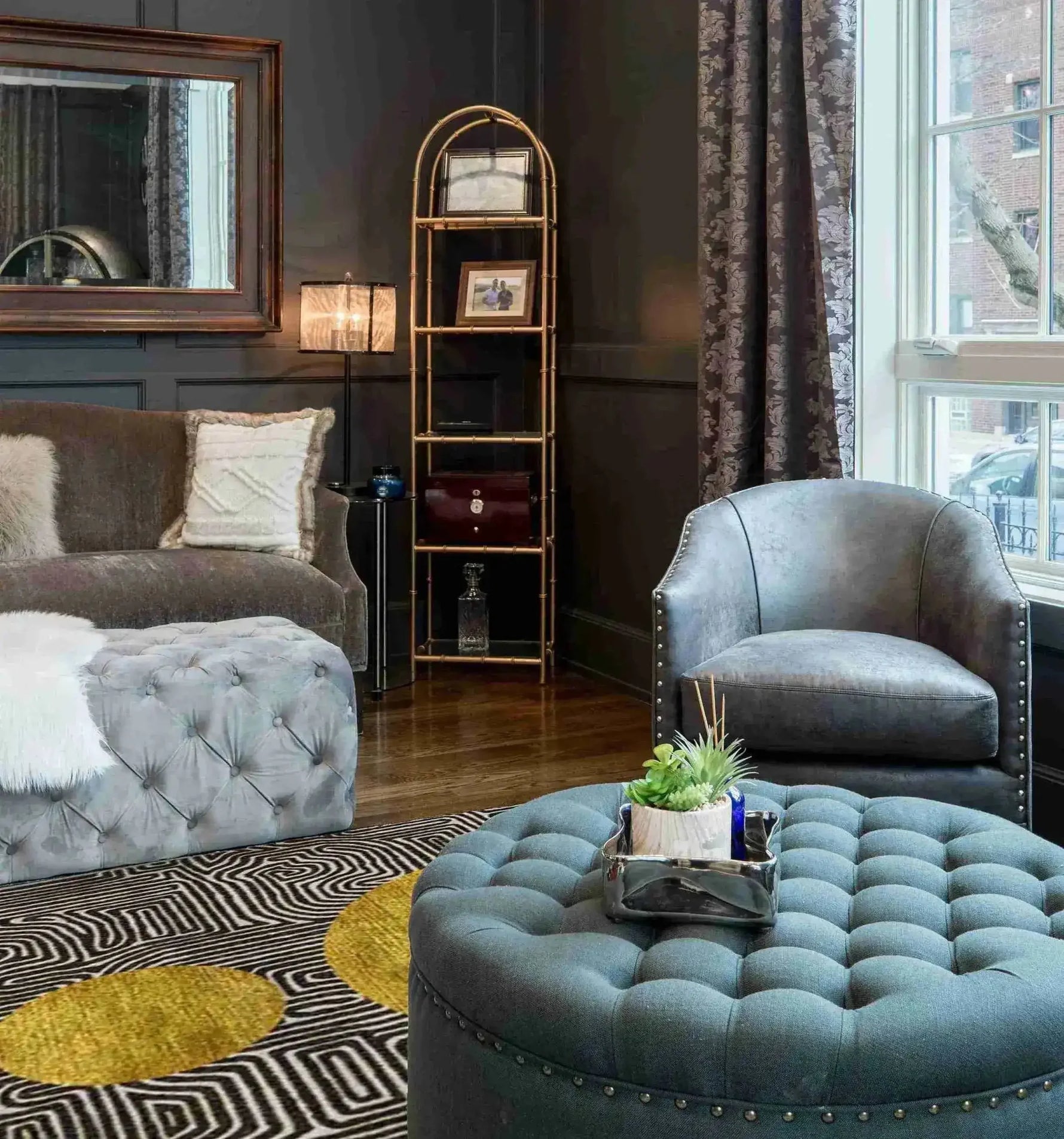 A stylish living room featuring a Three Golden Suns Maze Hand Tufted Wool Area Rug. The large area rug, perfect for living rooms 8x10, showcases a striking geometric design with golden sun patterns. It complements the elegant tufted furniture and sophisticated decor, adding warmth and style to the space.