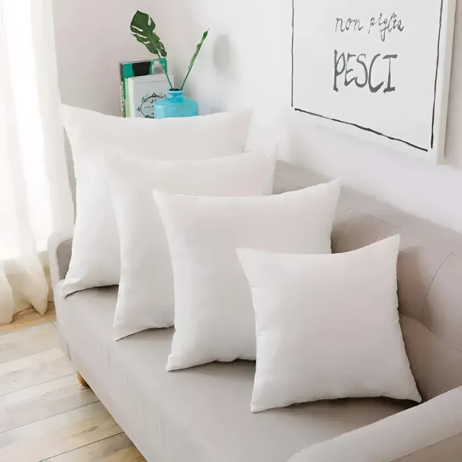 Collection of white throw pillows arranged on a couch, showcasing various sizes for decorative purposes.