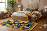 A vibrant Tibetan Tapestry Tufted Wool Rug featuring an abstract design with bold colors including blue, yellow, and orange. This contemporary area rug is perfect for adding a touch of artistry to large living rooms or offices.