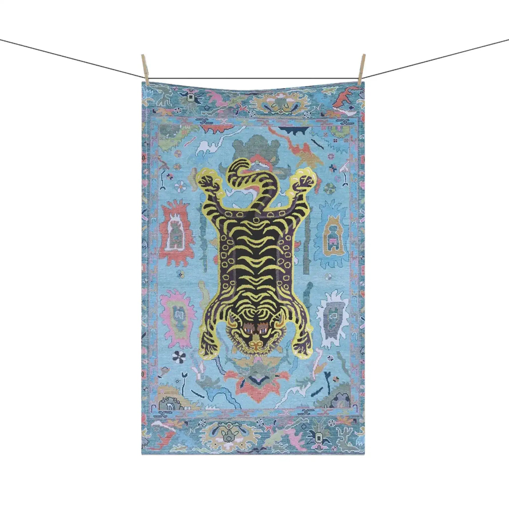Tibetan tiger kitchen towel hanging on clothesline, blue printed cotton with yellow-black tiger and colorful decorative border
