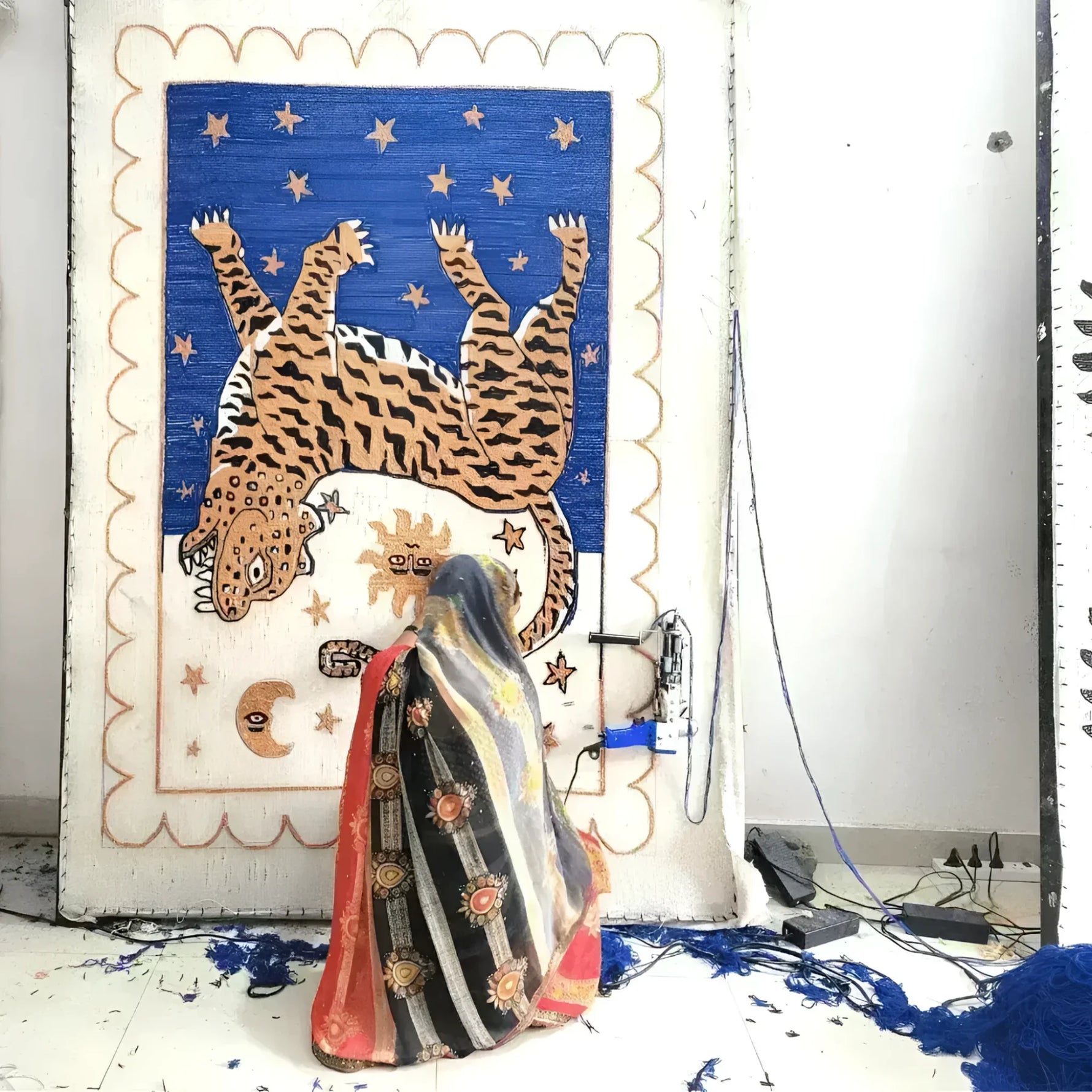 A skilled artisan hand tufting a Tibetan Tiger Starry Night Scallop Wool Rug. The area rug features a vivid depiction of a tiger and celestial motifs, perfect for large living rooms or as a vintage hallway runner rug. This wool rug combines traditional craftsmanship with a unique design, suitable for kitchen runner rugs or as a statement piece in an 8x10 living room setting.