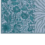 Close-up view of the Tidal Serenade Hand Tufted Wool Rug, showcasing intricate floral patterns in shades of teal and blue. This area rug is perfect for enhancing any living room, ideal for those seeking living room rugs in 8x10 size, crafted from high-quality wool.