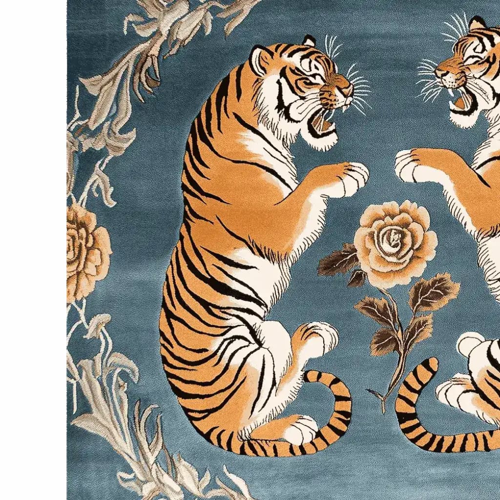 A striking hand-tufted wool rug featuring two majestic tigers facing each other on a rich blue background, surrounded by elegant floral designs. This vintage-style area rug adds a bold yet sophisticated touch to large living rooms, blending nature-inspired elements with a classic aesthetic.