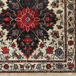 Close-up view of the Timeless Floral Medley Hand Knotted Wool Rug, showcasing intricate floral patterns in vibrant red and black tones on a beige background. Ideal for adding a touch of elegance to your living room or office, this vintage Persian-style area rug is perfect for those seeking 8x10 living room rugs.