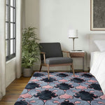 A stylish living room featuring the Timeless Symmetry Hand Tufted Area Rug. This contemporary wool rug showcases a vintage-inspired pattern in shades of pink, black, and gray. Perfectly sized at 8x10, it adds elegance to the wooden floor, complementing the modern furniture and decor. Ideal for those looking for sophisticated rugs for living room aesthetics.