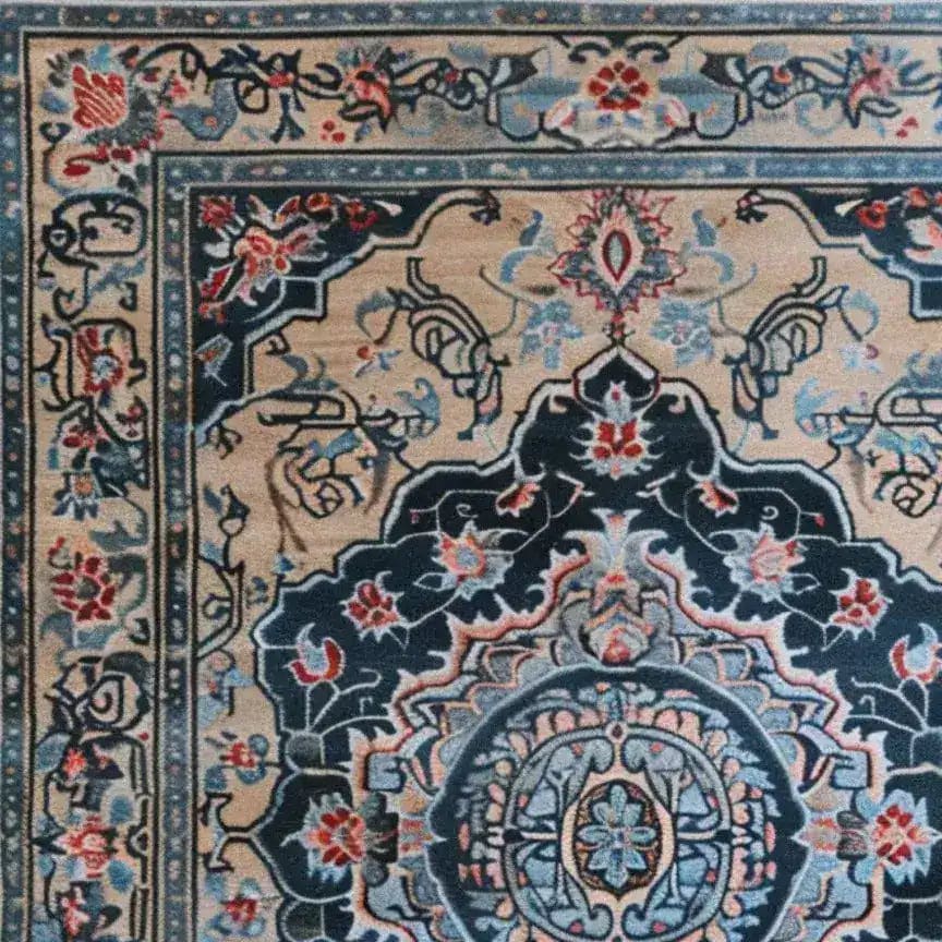 A close-up view of the Timeless Treasure Hand Tufted Rug, showcasing intricate floral and geometric patterns in rich blues, reds, and beige. This elegant wool area rug is perfect for enhancing the dining room or living room with a touch of vintage charm.