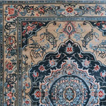 A close-up view of the Timeless Treasure Hand Tufted Rug, showcasing intricate floral and geometric patterns in rich blues, reds, and beige. This elegant wool area rug is perfect for enhancing the dining room or living room with a touch of vintage charm.