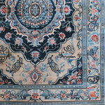 Close-up view of the Timeless Treasure Hand Tufted Rug, showcasing intricate vintage patterns in rich blues and reds, perfect for adding a touch of elegance to any living room or dining room. This wool rug serves as a stylish area rug, enhancing the beauty of your dining room carpets.