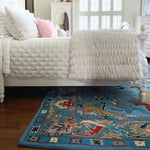 A beautifully designed traditional floral hand-tufted wool rug in blue, placed partially under a bed in a bright living room. This elegant area rug adds a touch of luxury and comfort, making it an ideal choice for rugs in living rooms.