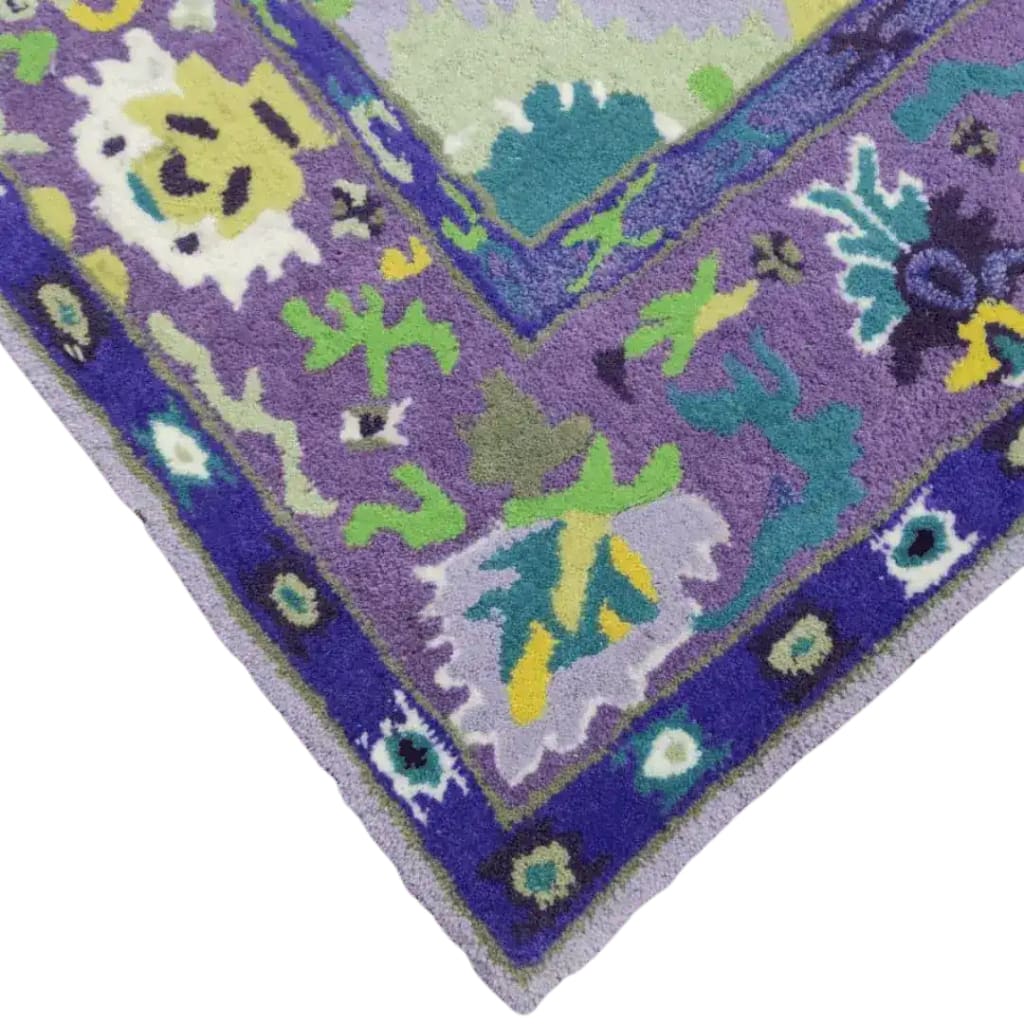 Close-up of a Traditional Floral Hand Tufted Wool Area Rug in purple, featuring vibrant green, blue, and yellow floral patterns. Perfect for adding a touch of elegance to your living room or office space.