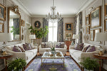 Elegant living room with white sofas, a purple traditional wool rug, decorative pillows, and a chandelier.