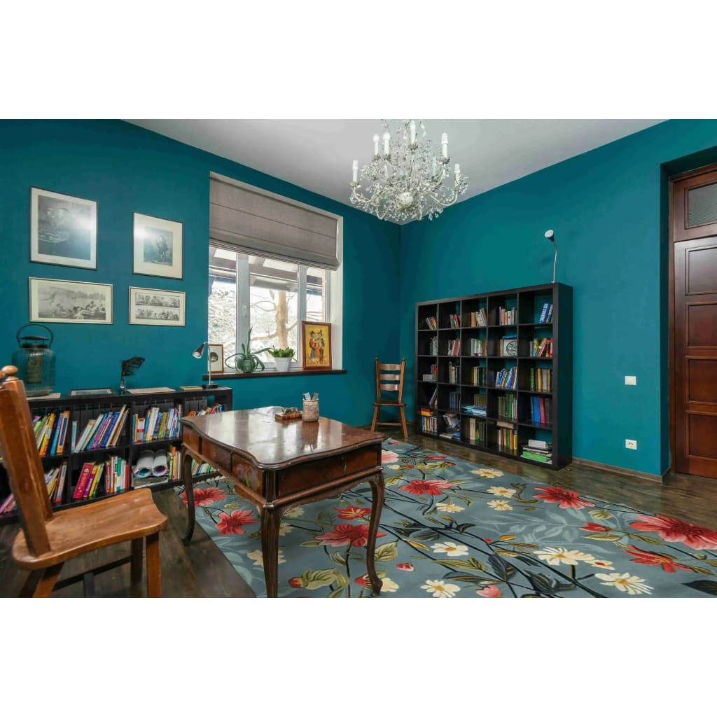 A vibrant living room showcasing the Tranquil Bloom Vista Hand Tufted Area Rug. This wool rug features a stunning floral design with red, yellow, and green hues, perfectly complementing the teal walls and wooden furniture. Ideal for adding a vintage touch to living room spaces or offices, this 8x10 area rug brings elegance and warmth to any setting.