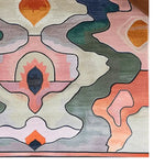 Close-up view of the Tranquil Mornings Hand Tufted Rug, showcasing an abstract design with earthy tones and organic shapes. This wool area rug is perfect for large living rooms or office spaces, adding a contemporary touch to any decor.