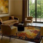 A stylish living room featuring a Treetops Tapestry Hand Tufted Area Rug. This large wool rug, perfect for a living room or bedroom, showcases an intricate vintage design with vibrant autumn colors. The square area rug adds a touch of elegance under the round coffee table, complementing the neutral furniture.