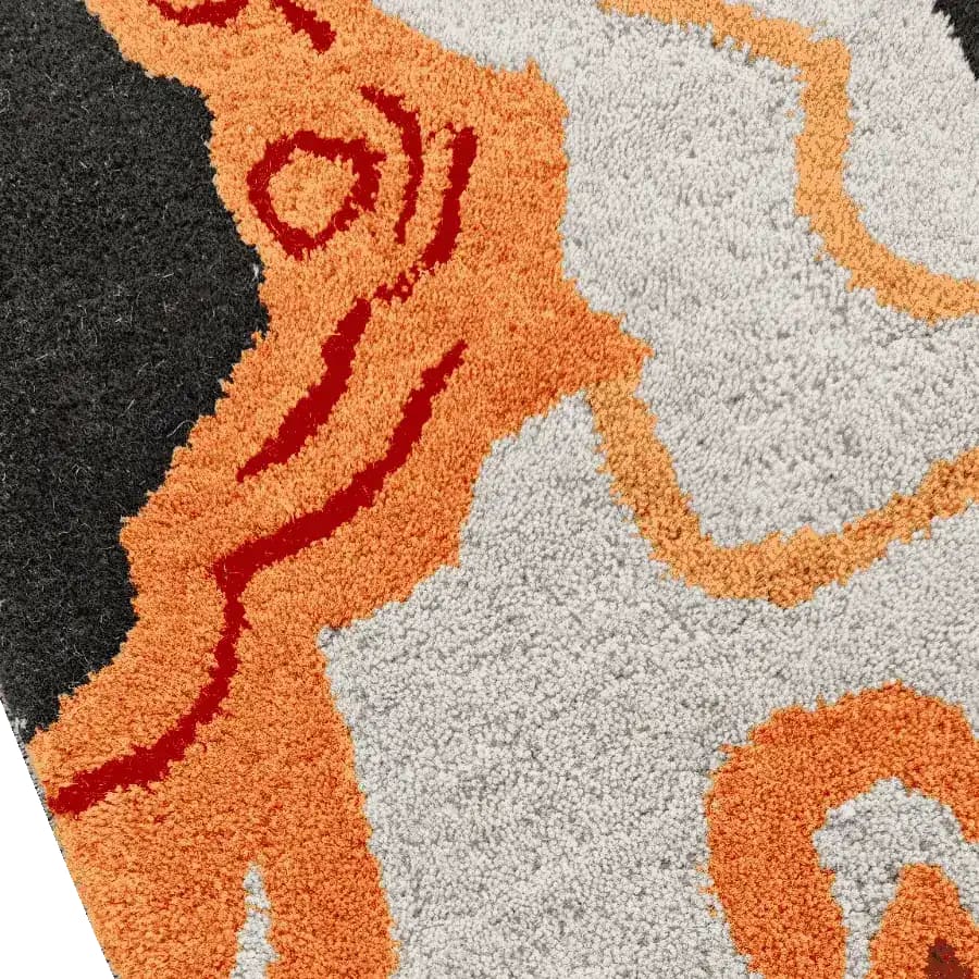 Close-up view of a vibrant hand tufted wool rug, showcasing a tribal tapestry design with bold orange, red, and cream patterns. Perfect for adding a contemporary touch to dining room area rugs or office spaces.