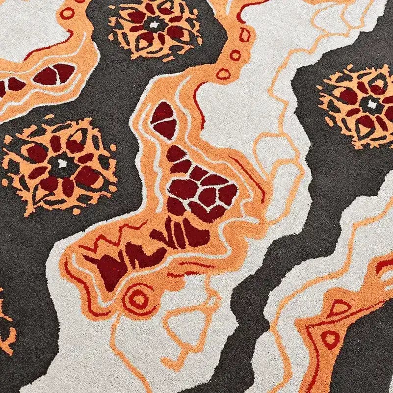 Close-up view of a Tribal Tapestry Hand Tufted Rug featuring bold abstract patterns in orange, red, and black, ideal for adding a contemporary touch to dining room area rugs or office spaces. This wool rug combines artistic flair with practical design, perfect for dining room carpets.