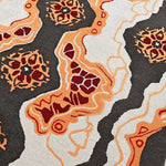 Close-up view of a Tribal Tapestry Hand Tufted Rug featuring bold abstract patterns in orange, red, and black, ideal for adding a contemporary touch to dining room area rugs or office spaces. This wool rug combines artistic flair with practical design, perfect for dining room carpets.