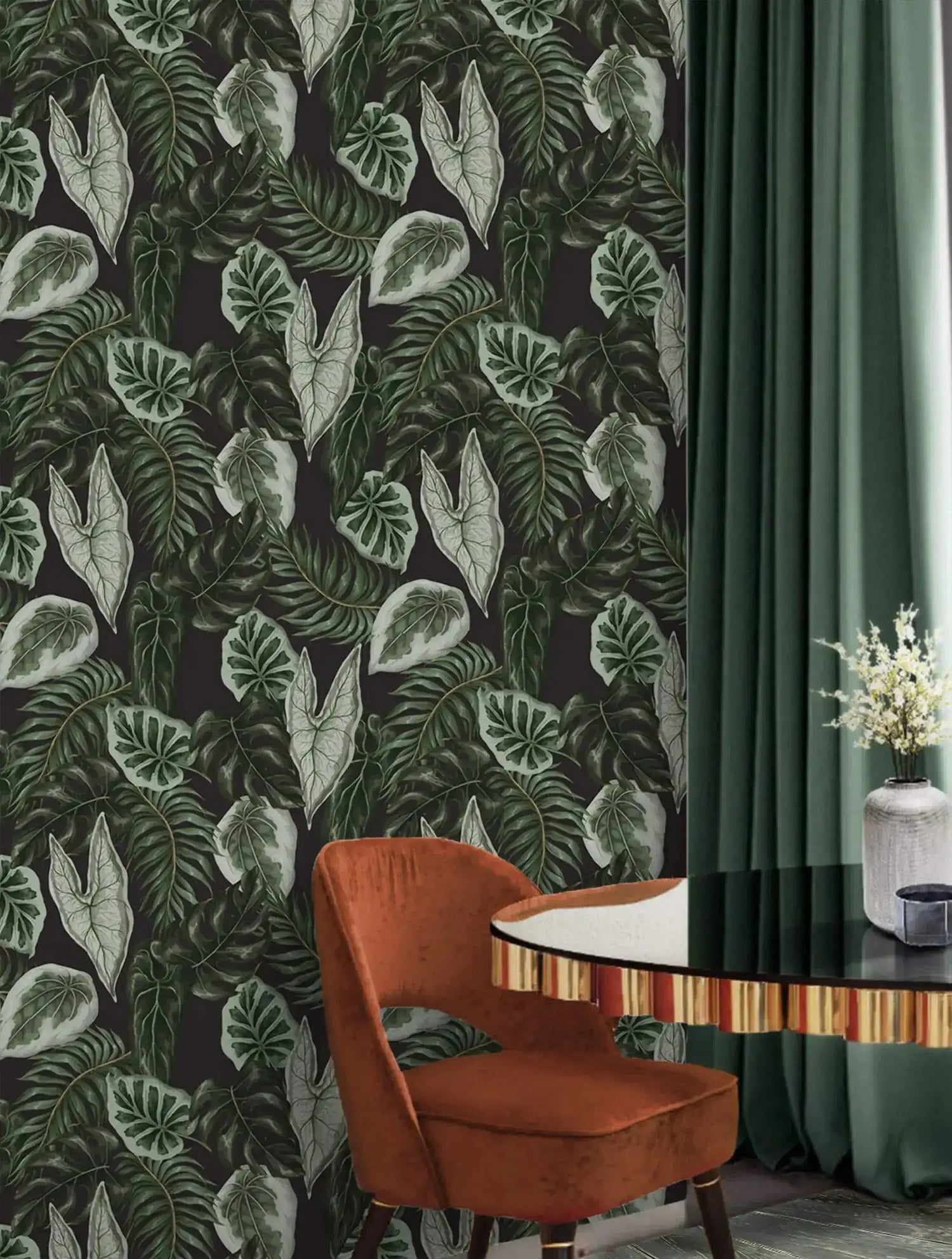 Tropical botanical wallpaper with green leaves on dark ground beside rust chair and sage curtain
