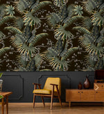Tropical canopy wallpaper of green palms on dark ground above charcoal panelling with a yellow retro chair