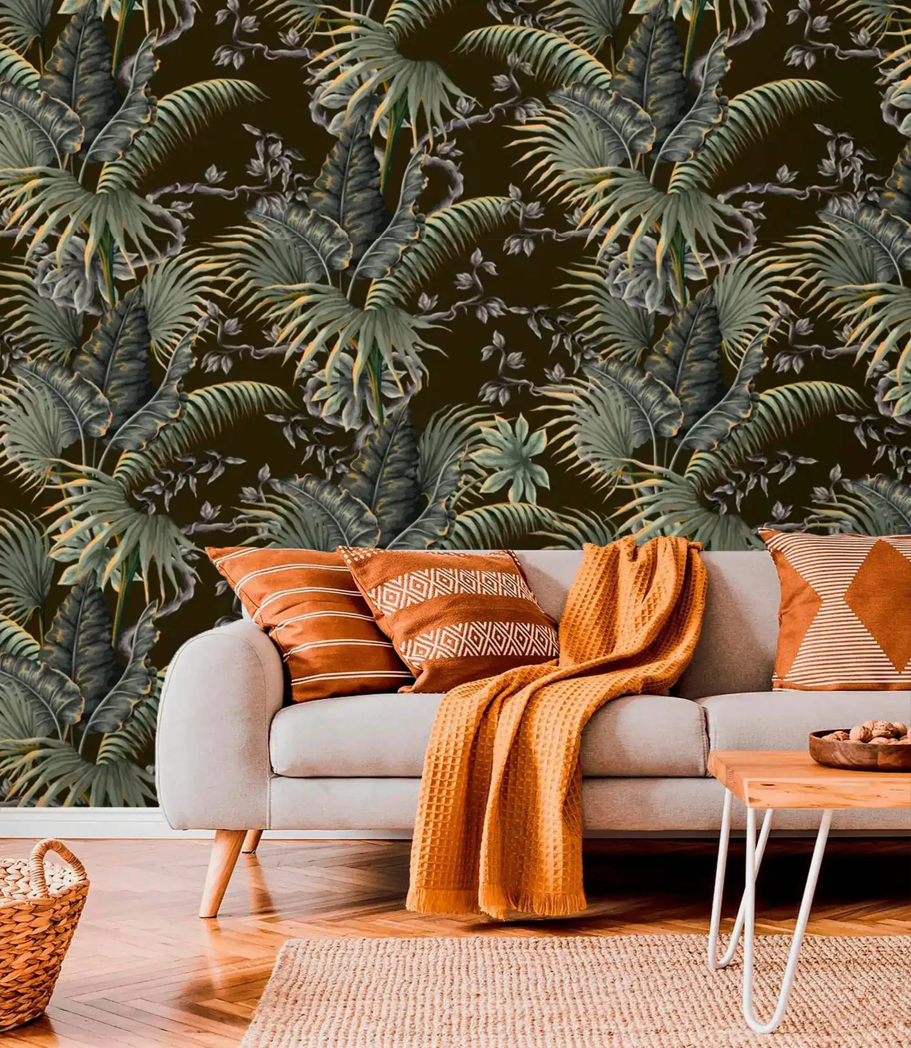 Tropical canopy wallpaper with dense green palm fronds on a dark ground behind a grey sofa with rust accents