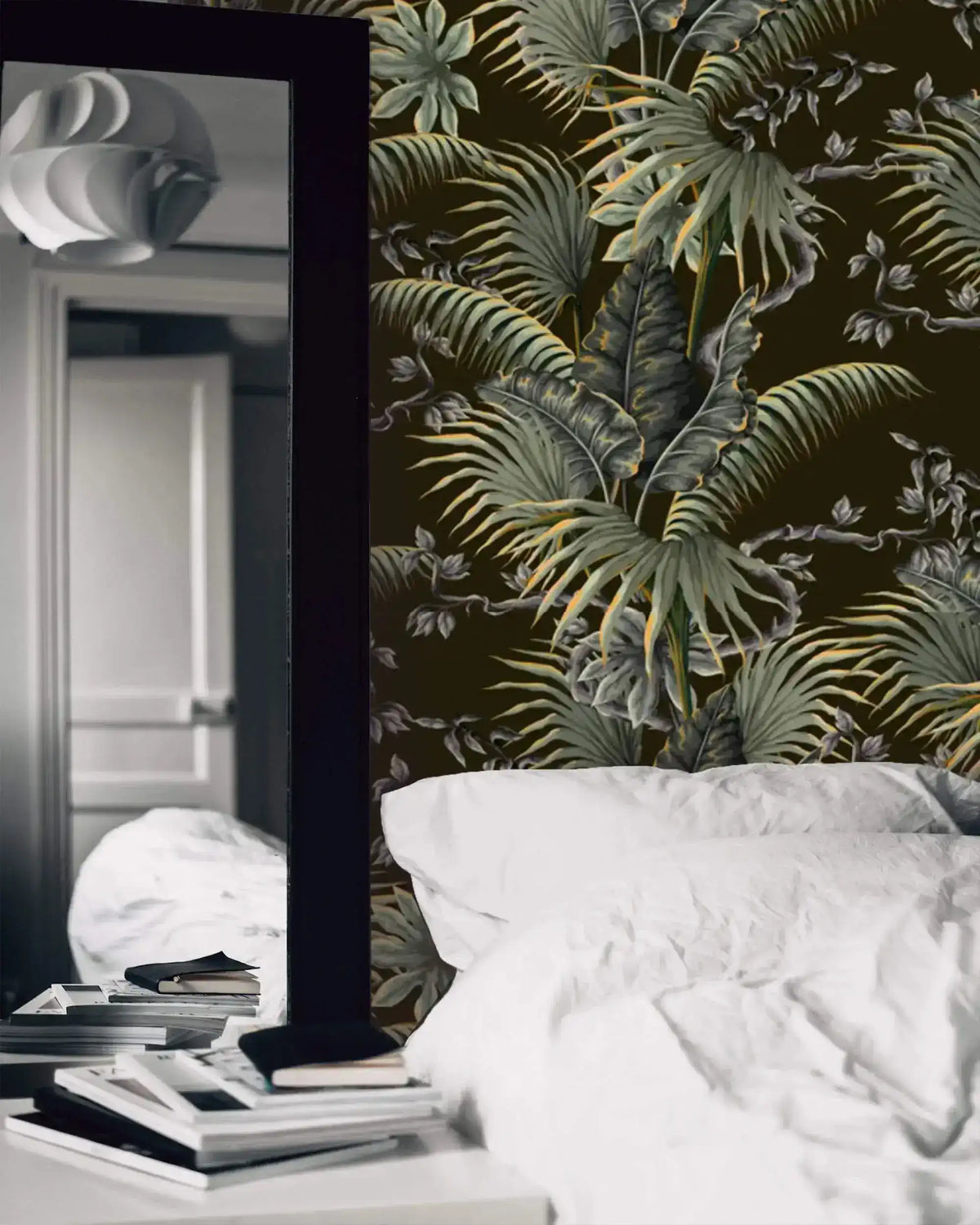 Tropical canopy wallpaper with detailed green ferns and palms on dark ground in a moody bedroom with white linens