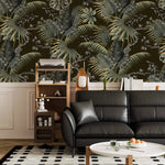 Tropical canopy wallpaper with green palm and monstera leaves above wainscoting in a living room with black sofa