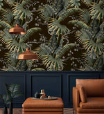 Tropical canopy wallpaper with green palm leaves on dark ground above navy panelling with copper pendant lamps