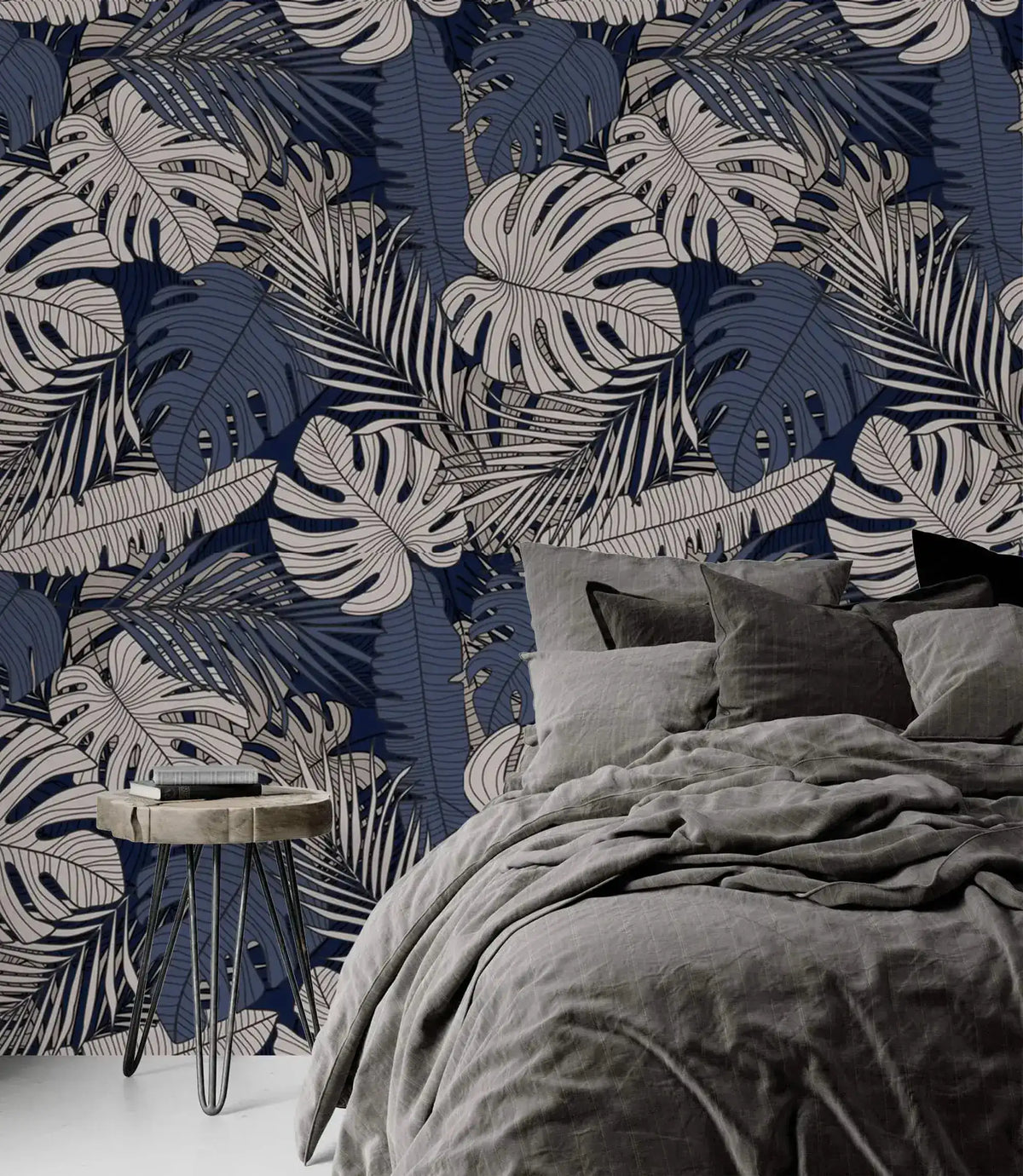 Tropical midnight leaves wallpaper on navy as headboard wall, paired with charcoal linen bedding and hairpin nightstand