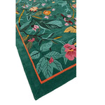 A vibrant Tropical Treasure hand-tufted wool rug, perfect for a large living room. This 4 x 6 ft area rug features a lush, colorful floral design with green leaves and pink flowers, ideal for adding a touch of nature to your living space.