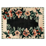 The Twilight Rose Parade Hand Tufted Area Rug features a stunning floral design. The rug showcases vibrant flowers in shades of red and orange, surrounded by lush green leaves, set against a dark background. This wool rug is perfect for adding elegance to living room decor and is an ideal choice for those seeking stylish area rugs for living rooms.