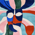 Vibrant and artistic area rug showcasing an abstract design with bold colors like blue, red, green, and pink. This contemporary wool rug is perfect for adding a splash of color to your living room. The hand-tufted square area rug is both stylish and functional, ideal for modern home decor.