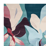 A vibrant, hand-tufted area rug showcasing a modern floral design with bold colors, perfect for large living rooms. This contemporary wool rug features overlapping blossoms in shades of teal, burgundy, and pink, creating a stunning centerpiece for any space.