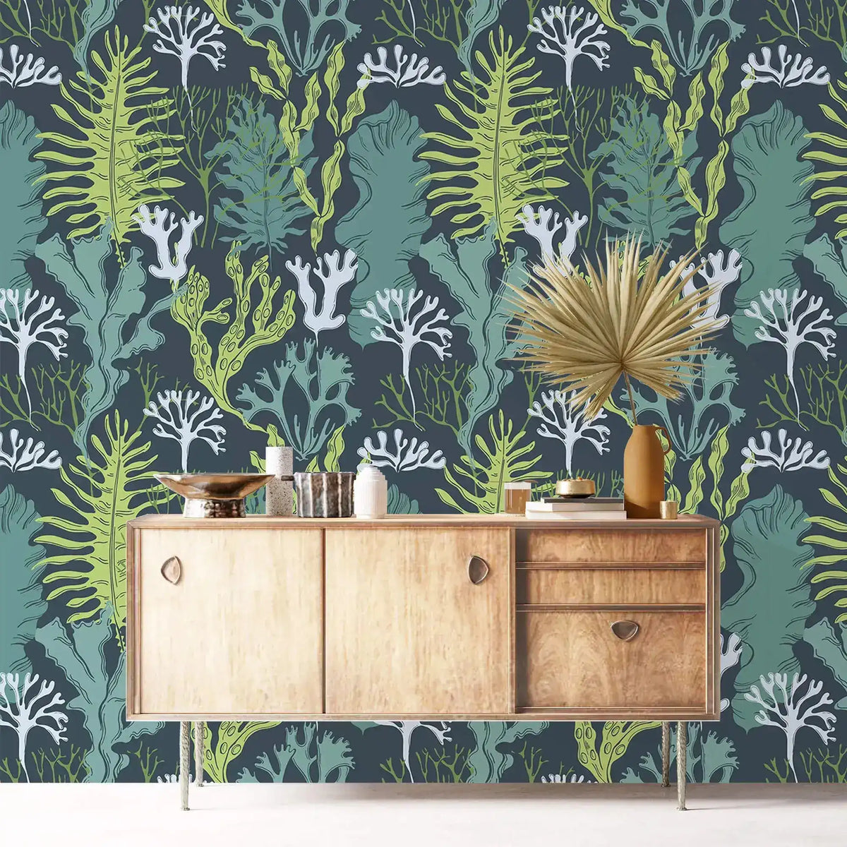 Underwater Flora Wallpaper of green seaweed and white coral on teal behind a wood sideboard