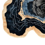 Top view of the Unexpected Pup Hand Tufted Wool Rug, showcasing its abstract design with swirling patterns in shades of black, beige, and blue. This contemporary area rug is ideal for adding a modern touch to living room spaces. Perfect as a living room rug 8x10, this wool rug combines style and comfort.