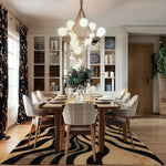 Stylish dining room featuring an Urban Abstract Tufted Wool Rug with a unique black and beige pattern. This contemporary area rug adds a touch of elegance to the living room or office space, complementing the modern decor and chic dining set.