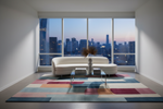 Modern living room with a colorful rug, white sofa, and cityscape view.