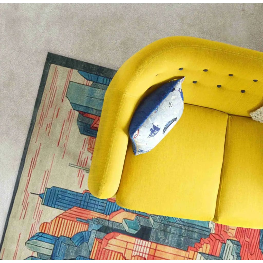Top view of a vibrant Urban Skyline Hand Tufted Area Rug in a contemporary living room setting. The wool rug features abstract cityscape patterns, adding a modern touch to formal dining room and living room spaces. A bright yellow sofa with a decorative pillow complements the rug, making it ideal for both dining room and living room decor.