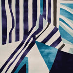 A vibrant area rug with bold stripes in shades of blue, white, and black, perfect for adding a contemporary touch to any living room. This wool rug features an abstract design that makes it an ideal choice for modern home decor, offering both style and comfort as a living room area rug.