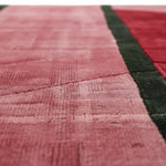 Close-up of a textured pink and green rug