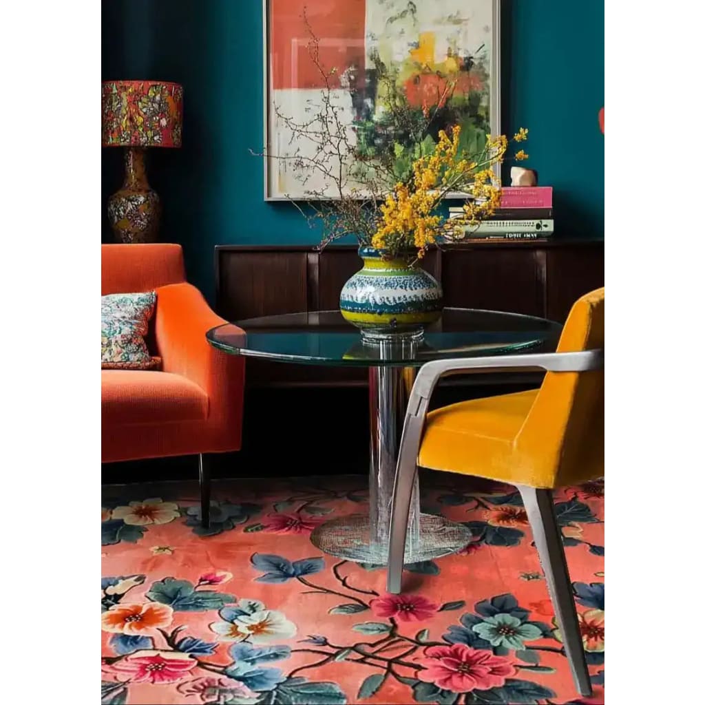 A vibrant, floral wool area rug beautifully enhances a cozy living room setting. The large living room rug features bold, colorful flowers against a warm background, complementing the deep blue walls and eclectic decor. Perfect as a living room rug 8x10, it adds a touch of elegance to both living rooms and bedrooms.